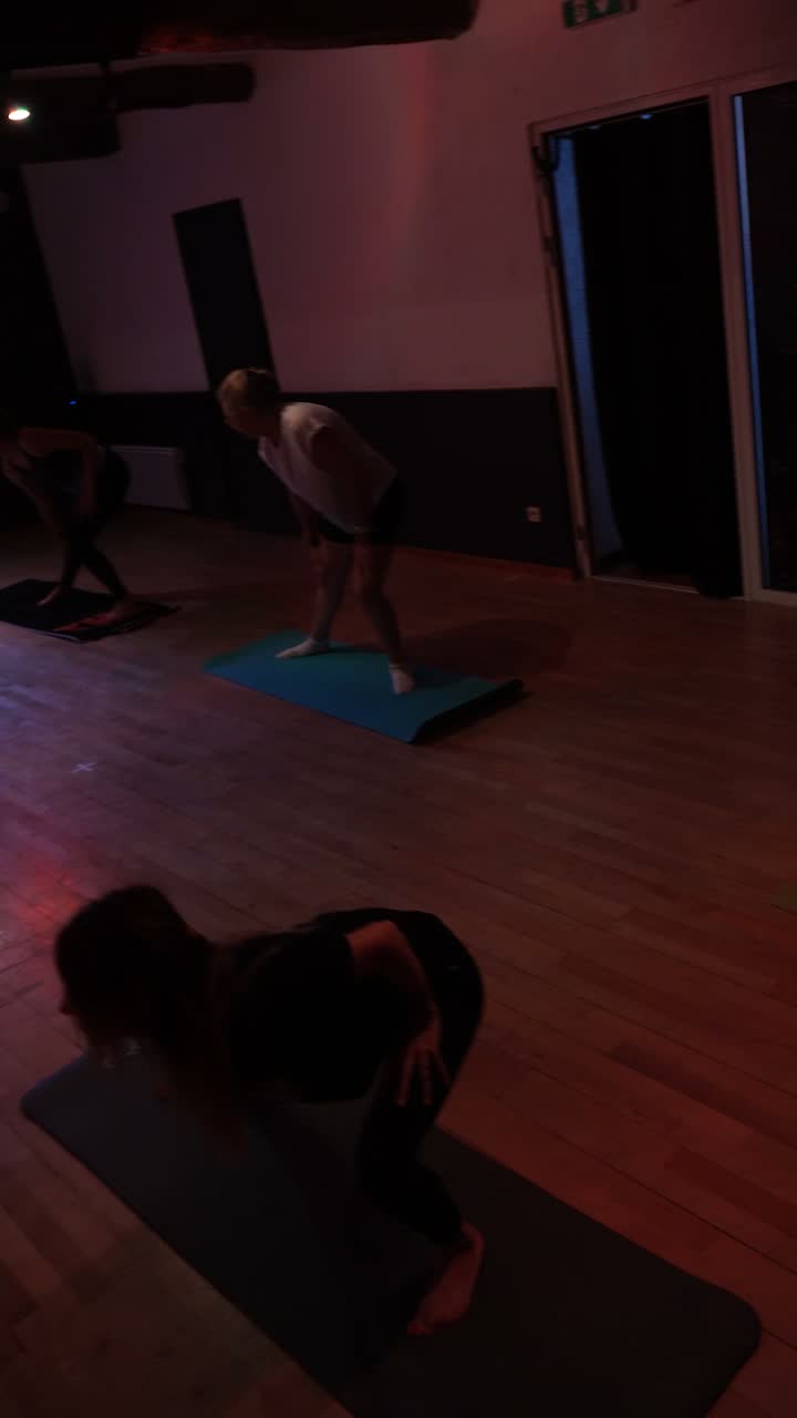Un cours de stretching au studio : tapis au sol, parquet et lumière tamisée.