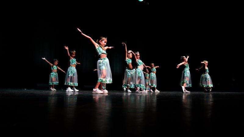 Les enfants en robes bleu clair, bras levés.