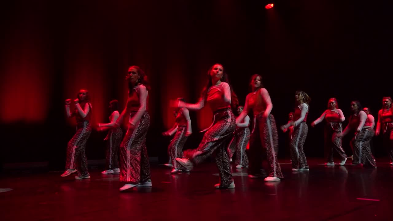 Le groupe ragga et afro niveau 1 en tenues imprimées, sous une lumière rouge.